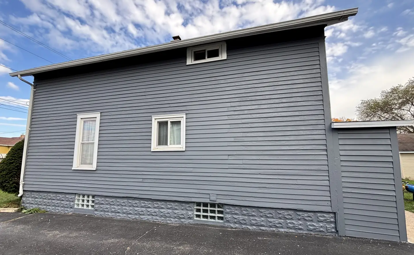 Gray siding with white window trim, finished.