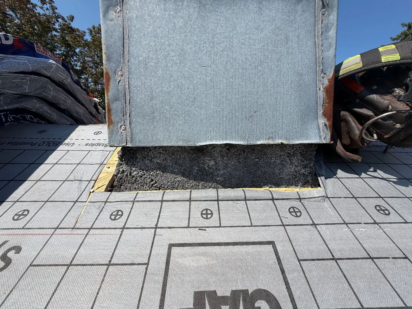 Synthetic underlayment run up to the chimney. The flashing gets cut in and replaced before any shingles go on around it.