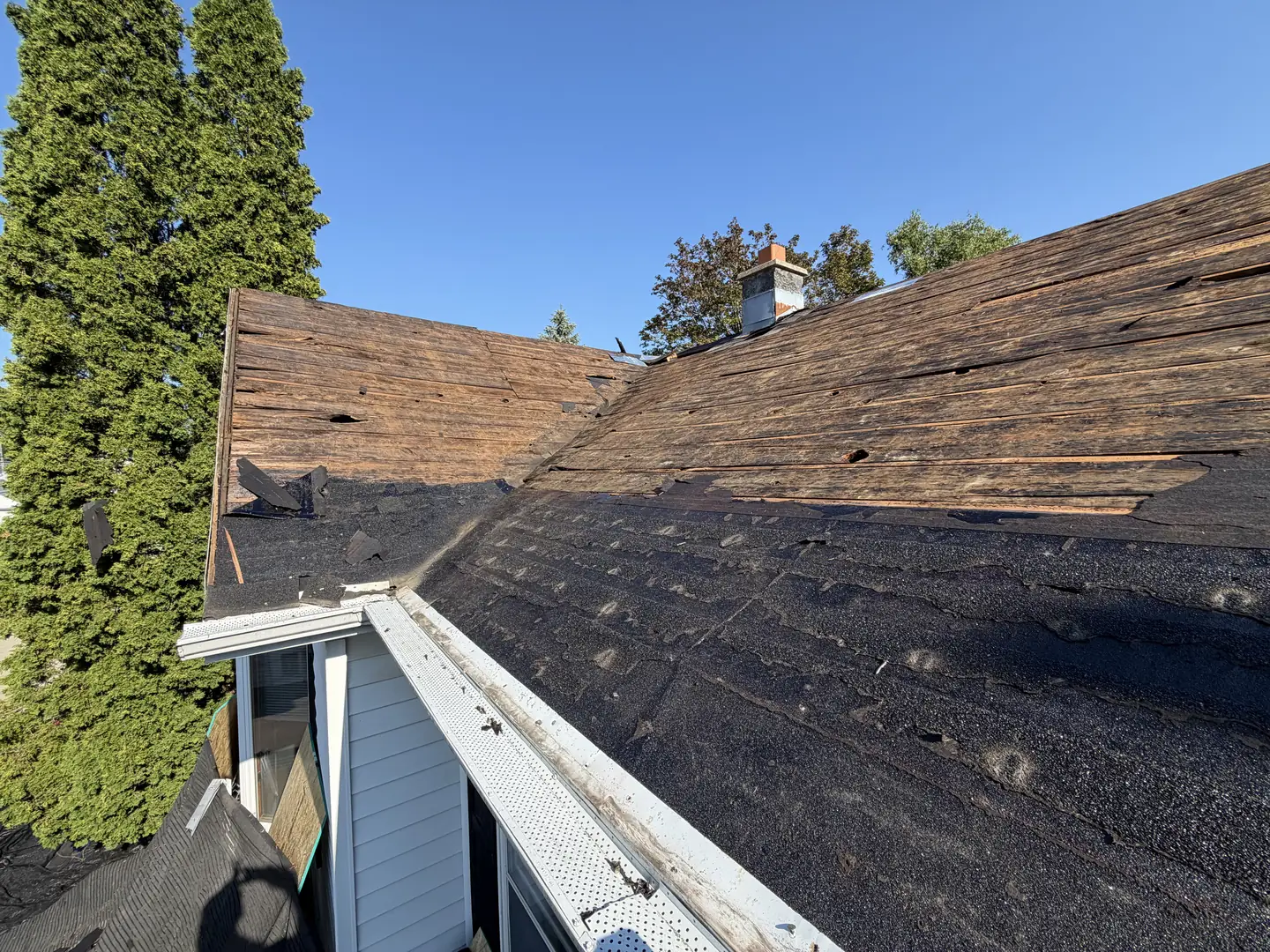 A roof stripped back to its original plank decking during a tear-off
